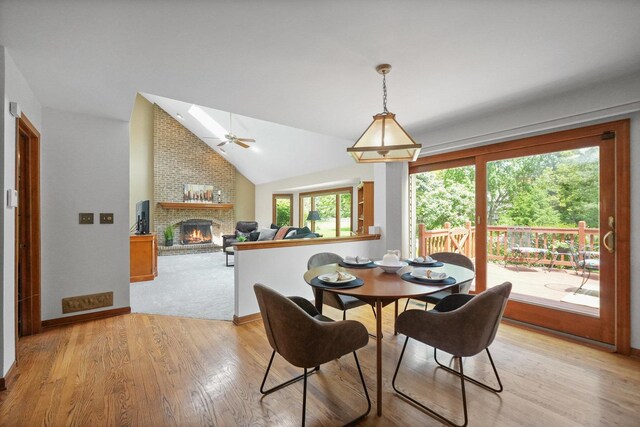 2756 Fox River Ln, Naperville, IL 60565 - dining room featuring a brick fireplace, lofted ceiling, light wood-type flooring, a ceiling fan, and baseboards