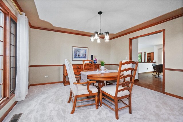 2756 Fox River Ln, Naperville, IL 60565 - dining area with light colored carpet, ornamental molding, baseboards, and a chandelier