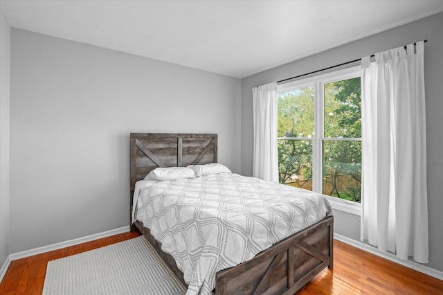 bedroom with baseboards and wood finished floors