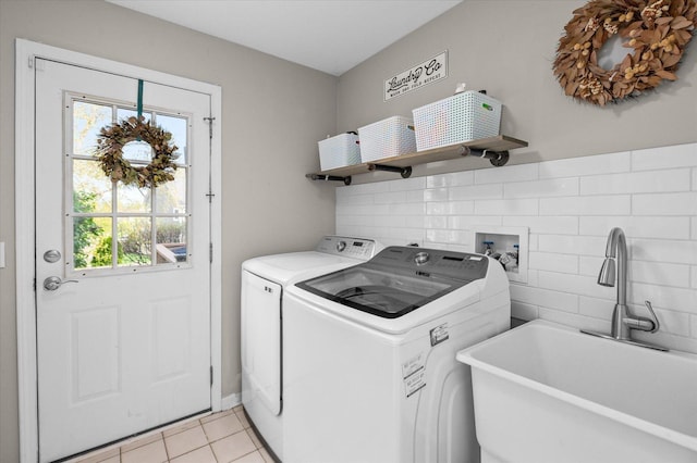 laundry area featuring a sink, light tile patterned floors, laundry area, and washer and clothes dryer