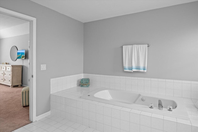 bathroom with baseboards, tile patterned floors, and a bath