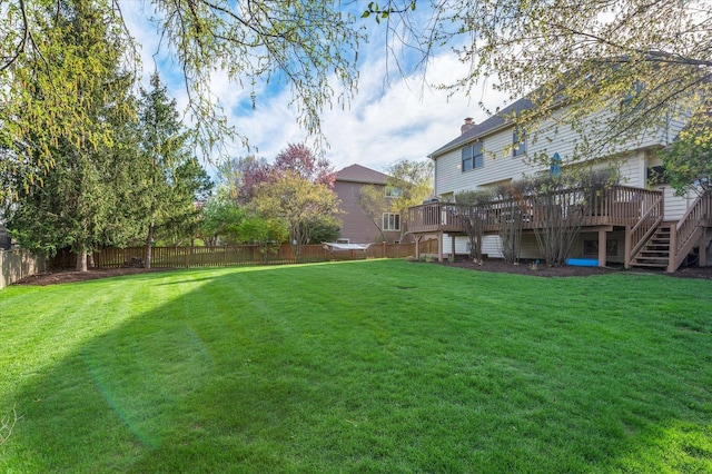 view of yard featuring a fenced backyard, a deck, and stairway