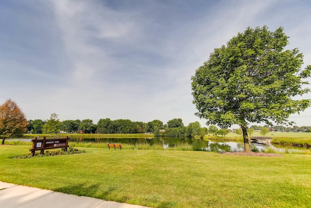 view of property's community with a water view and a yard