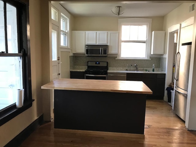 7748 S Saginaw Ave, Chicago, IL 60649 - kitchen with stainless steel appliances, a sink, tasteful backsplash, and white cabinetry