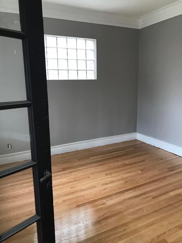 7748 S Saginaw Ave, Chicago, IL 60649 - unfurnished room with ornamental molding, wood finished floors, and baseboards