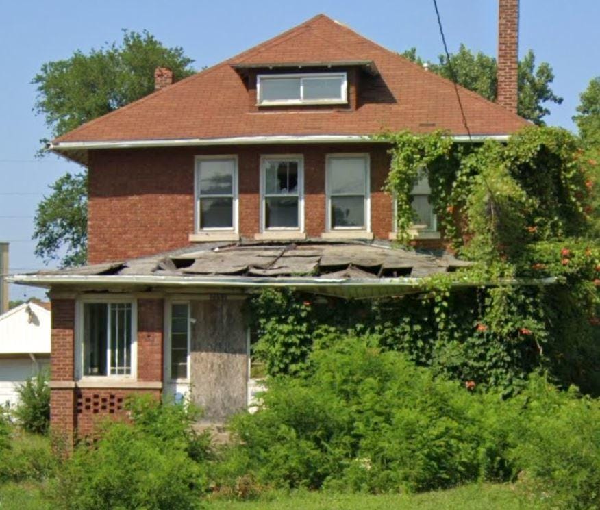 back of property with a chimney and brick siding