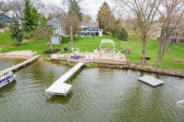 view of dock featuring a lawn and a water view