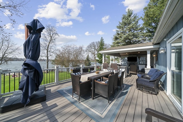 wooden terrace featuring a water view and outdoor dining space