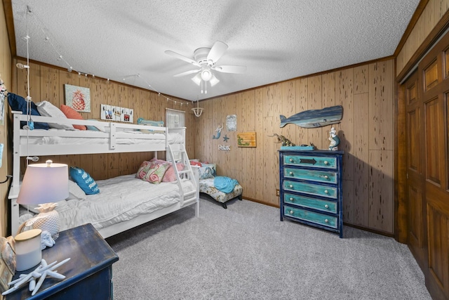 carpeted bedroom with a textured ceiling, wood walls, and a ceiling fan