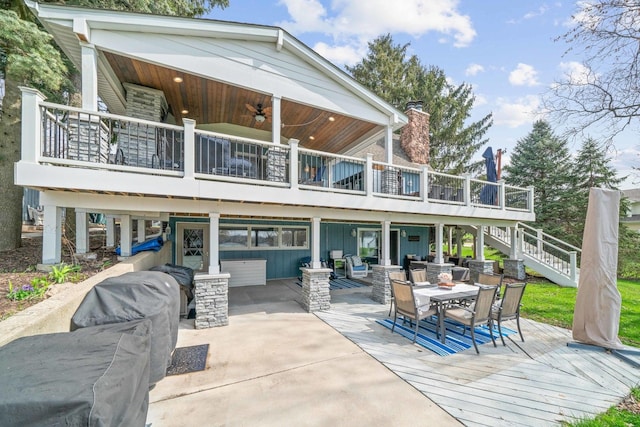 rear view of property featuring outdoor dining area, a deck, stairs, and ceiling fan