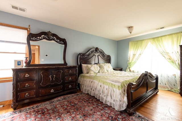 bedroom featuring visible vents and wood finished floors