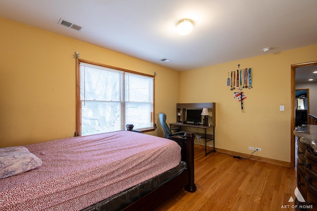 bedroom featuring visible vents, light wood-type flooring, and baseboards