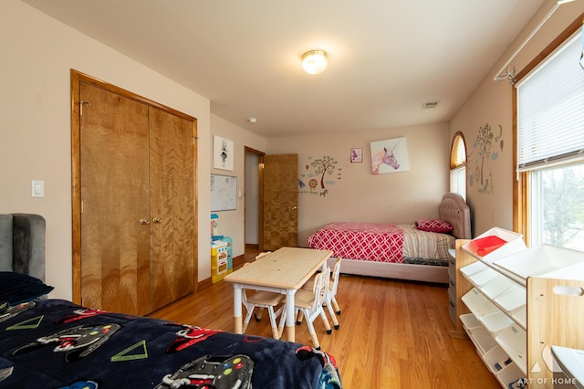 bedroom with a closet, light wood-style flooring, and visible vents