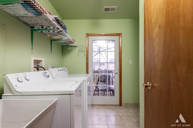washroom featuring laundry area, visible vents, light tile patterned flooring, baseboards, and washing machine and dryer