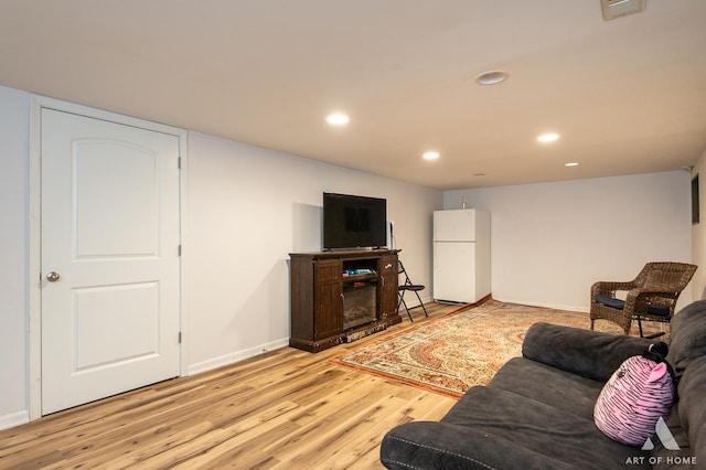 living area with light wood-style floors, baseboards, visible vents, and recessed lighting