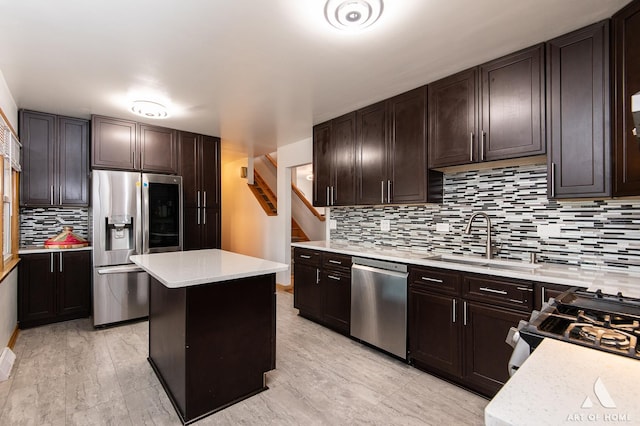 kitchen featuring a sink, light countertops, appliances with stainless steel finishes, dark brown cabinetry, and decorative backsplash