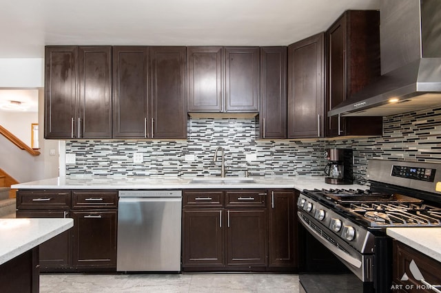 kitchen featuring decorative backsplash, a sink, wall chimney range hood, and stainless steel appliances