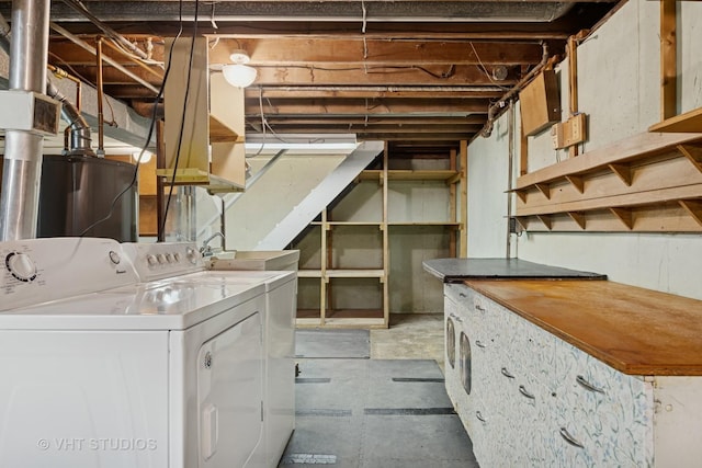 unfinished below grade area featuring water heater, independent washer and dryer, and a sink