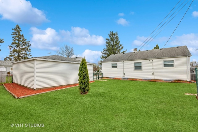 back of house featuring a yard and fence