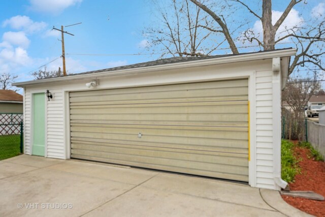 detached garage featuring fence