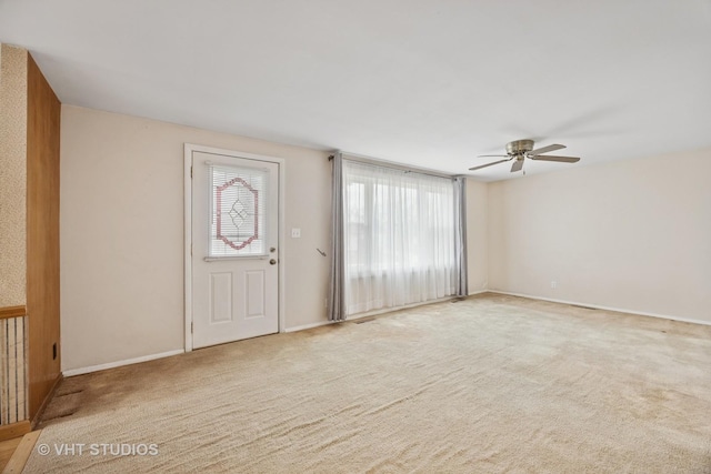carpeted entrance foyer featuring baseboards and ceiling fan
