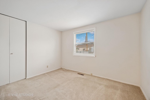 unfurnished bedroom with a closet, visible vents, carpet flooring, and baseboards