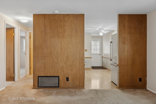 unfurnished room with baseboards, visible vents, a fireplace, and ceiling fan