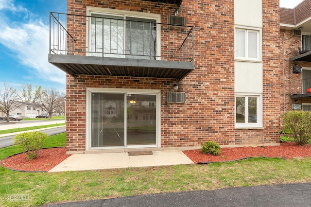 doorway to property with brick siding and a balcony