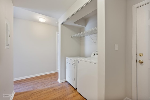 laundry room featuring laundry area, baseboards, washer and dryer, and light wood-style floors