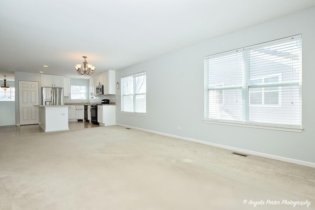 1244 Chesterton Dr Unit 1244, Fox Lake, IL 60020 - unfurnished living room with an inviting chandelier, visible vents, and baseboards