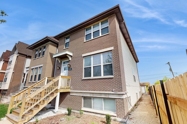 view of front of home with brick siding and fence
