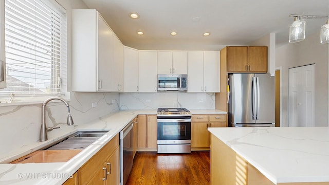 kitchen featuring dark wood-style flooring, appliances with stainless steel finishes, a sink, recessed lighting, and decorative backsplash