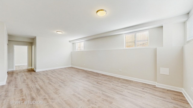 basement featuring baseboards and light wood-type flooring
