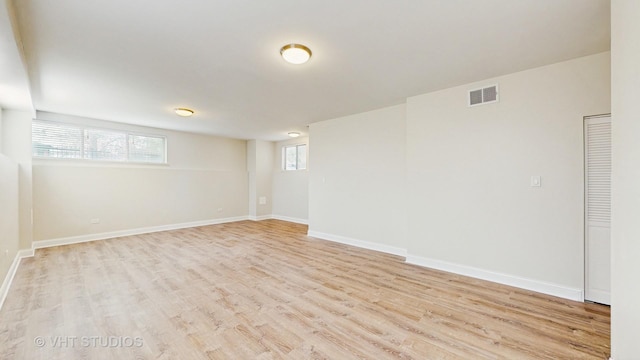 basement featuring visible vents, baseboards, and wood finished floors