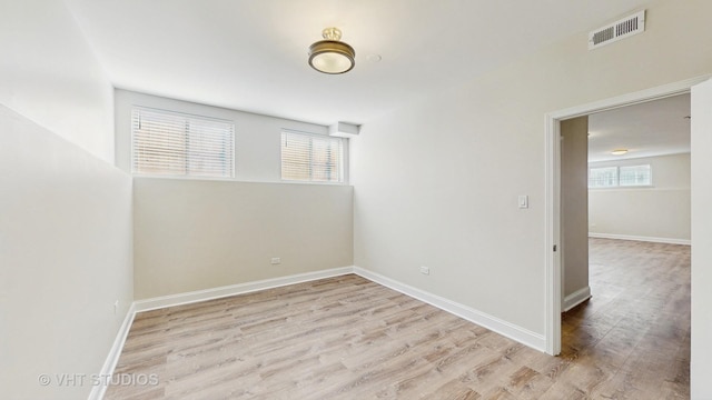 empty room with visible vents, baseboards, and wood finished floors
