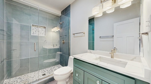 full bath with vanity, a stall shower, and toilet