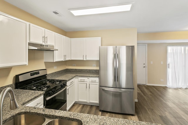 924 Symphony Dr Unit 7036, Aurora, IL 60504 - kitchen with dark stone countertops, under cabinet range hood, stainless steel appliances, white cabinetry, and dark wood-type flooring
