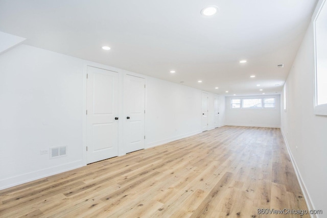 interior space with baseboards, light wood finished floors, visible vents, and recessed lighting