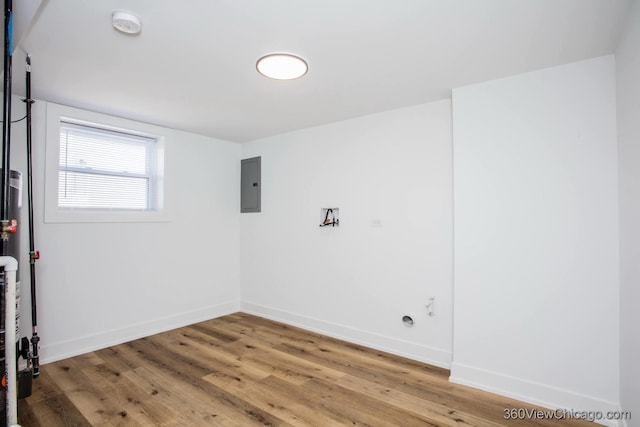 interior space featuring electric panel, light wood-style flooring, and baseboards