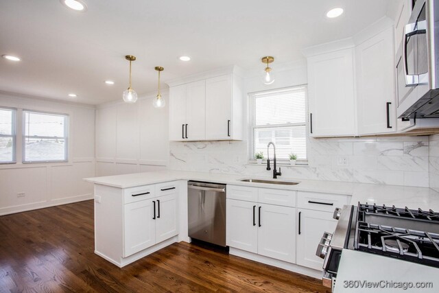 kitchen with a peninsula, a healthy amount of sunlight, stainless steel appliances, and a sink