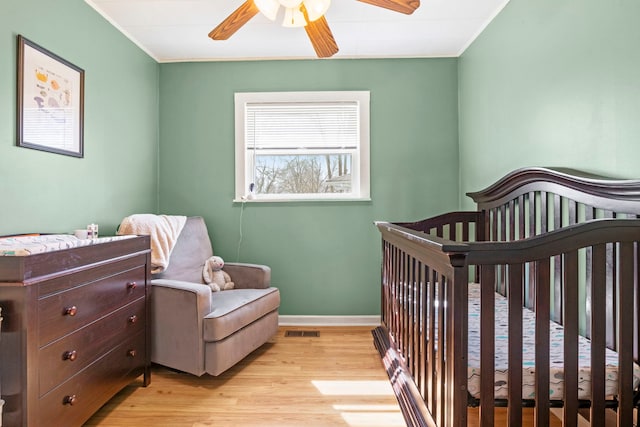 26 S Victoria Ln, Streamwood, IL 60107 - bedroom with a nursery area, crown molding, ceiling fan, light wood-style flooring, and baseboards