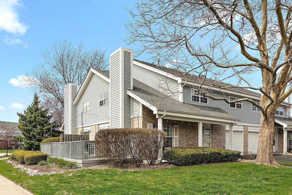 7104 Olde Gatehouse Rd, Tinley Park, IL 60477 - view of home's exterior with a garage, a chimney, a lawn, aphalt driveway, and brick siding