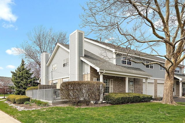 view of home's exterior with a garage, a chimney, a lawn, aphalt driveway, and brick siding