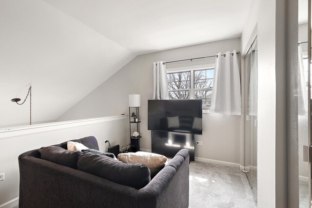 living area with carpet flooring, vaulted ceiling, and baseboards