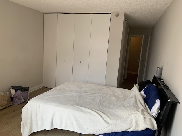 200 N Dearborn St Unit 2406, Chicago, IL 60601 - bedroom featuring a closet, wood finished floors, and a textured ceiling