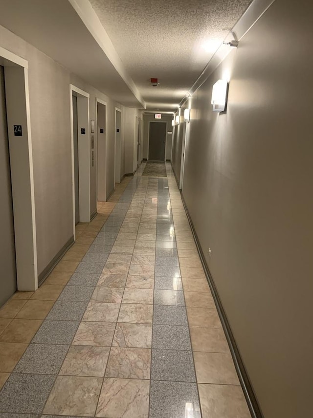 200 N Dearborn St Unit 2406, Chicago, IL 60601 - hallway featuring a textured ceiling, elevator, and baseboards