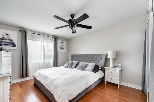 bedroom featuring wood finished floors, baseboards, and ceiling fan