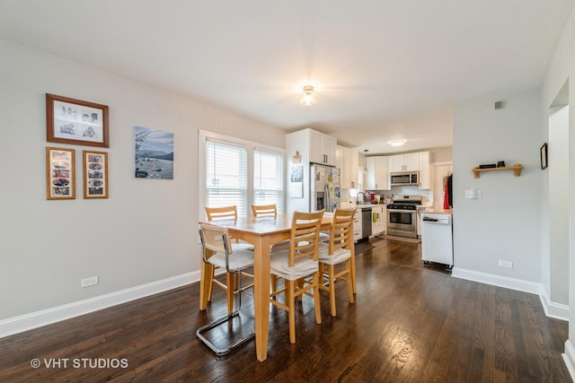 138 W Kenilworth Ave, Villa Park, IL 60181 - kitchen with dark wood finished floors, light countertops, decorative light fixtures, appliances with stainless steel finishes, and white cabinetry