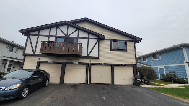 6084 Fremont Dr Unit 6084, Hanover Park, IL 60133 - tudor-style house with a garage, driveway, and a balcony