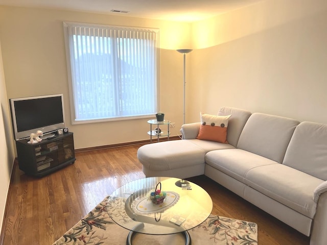 living room featuring baseboards, wood finished floors, and visible vents